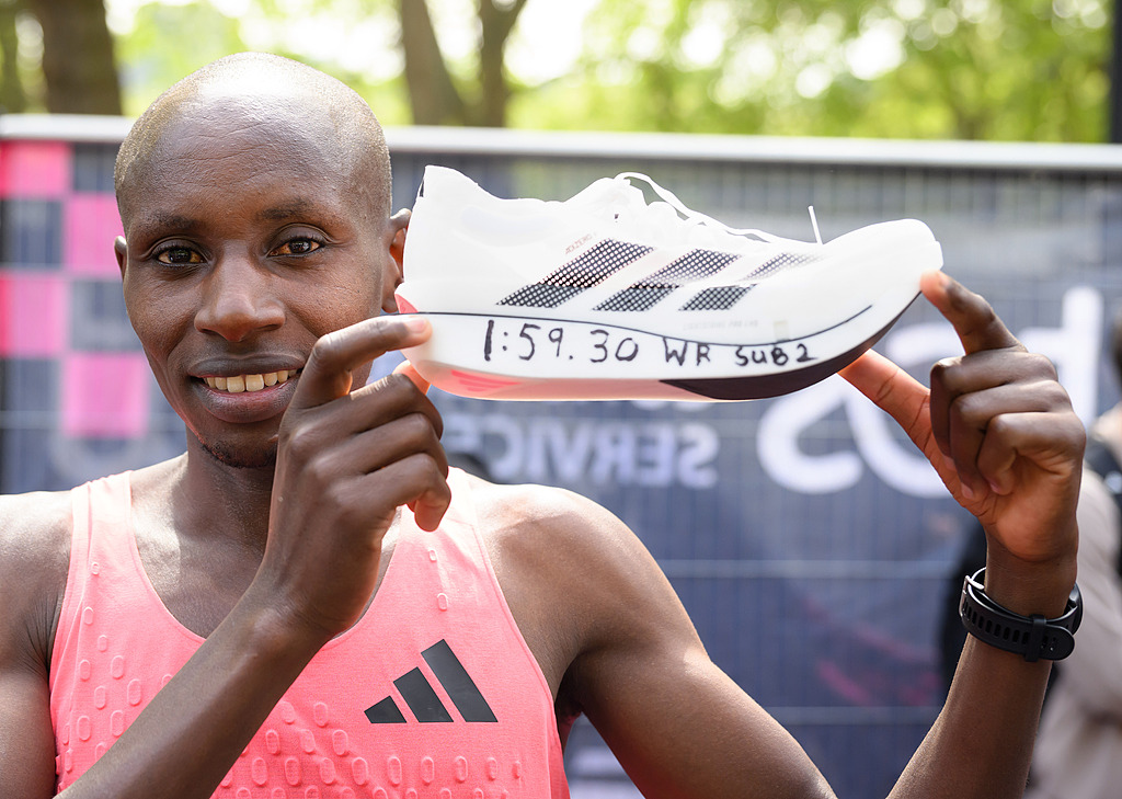 Sabastian Sawe of Team Kenya celebrates with his shoe after winning with a new World Record time during the Men’s 2026 London Marathon on April 26, 2026 in London, UK. /VCG