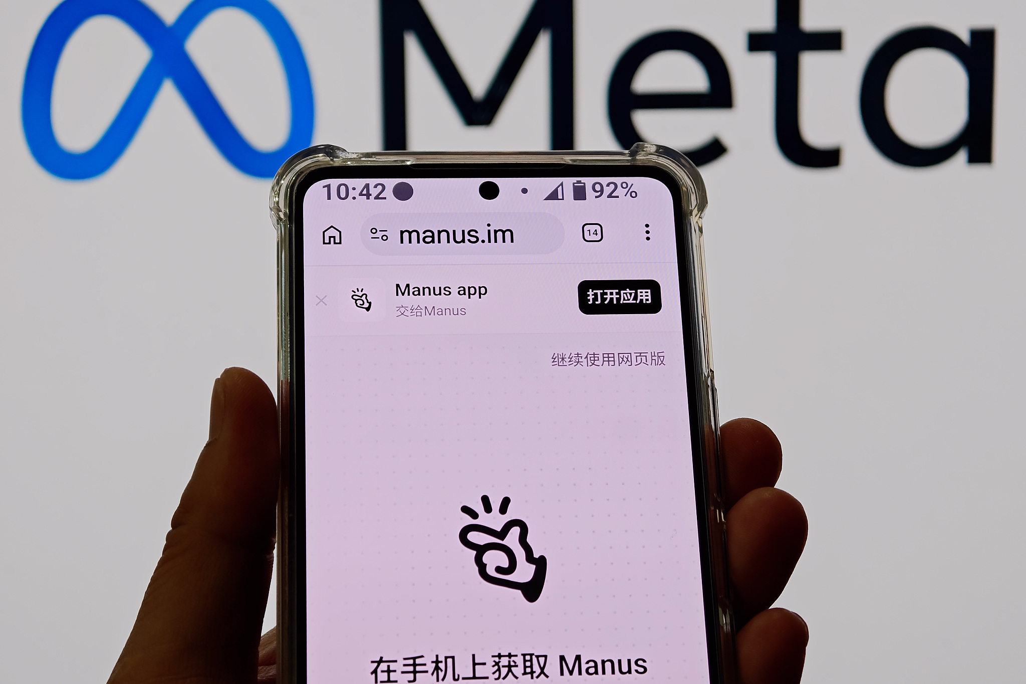 The Manus logo is seen on a mobile phone screen with a Meta logo in the background, April 28, 2026. /VCG