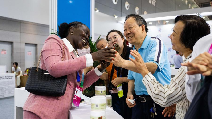 An exhibitor (L) chats with visitors during the fourth China-Africa Economic and Trade Expo at Changsha International Convention and Exhibition Center in Changsha, central China's Hunan Province, June 13, 2025. /Xinhua