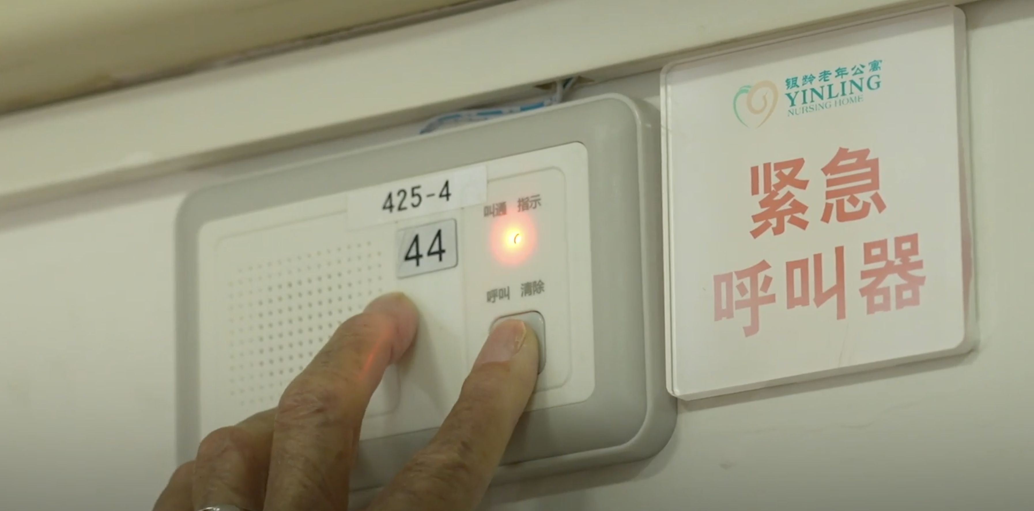 A resident presses the emergency call button at Yinling Elderly Nursing Home in Wulao Xinjie, Beijing. Each bed at the home has its own emergency call button for quick response to residents in need. /CGTN