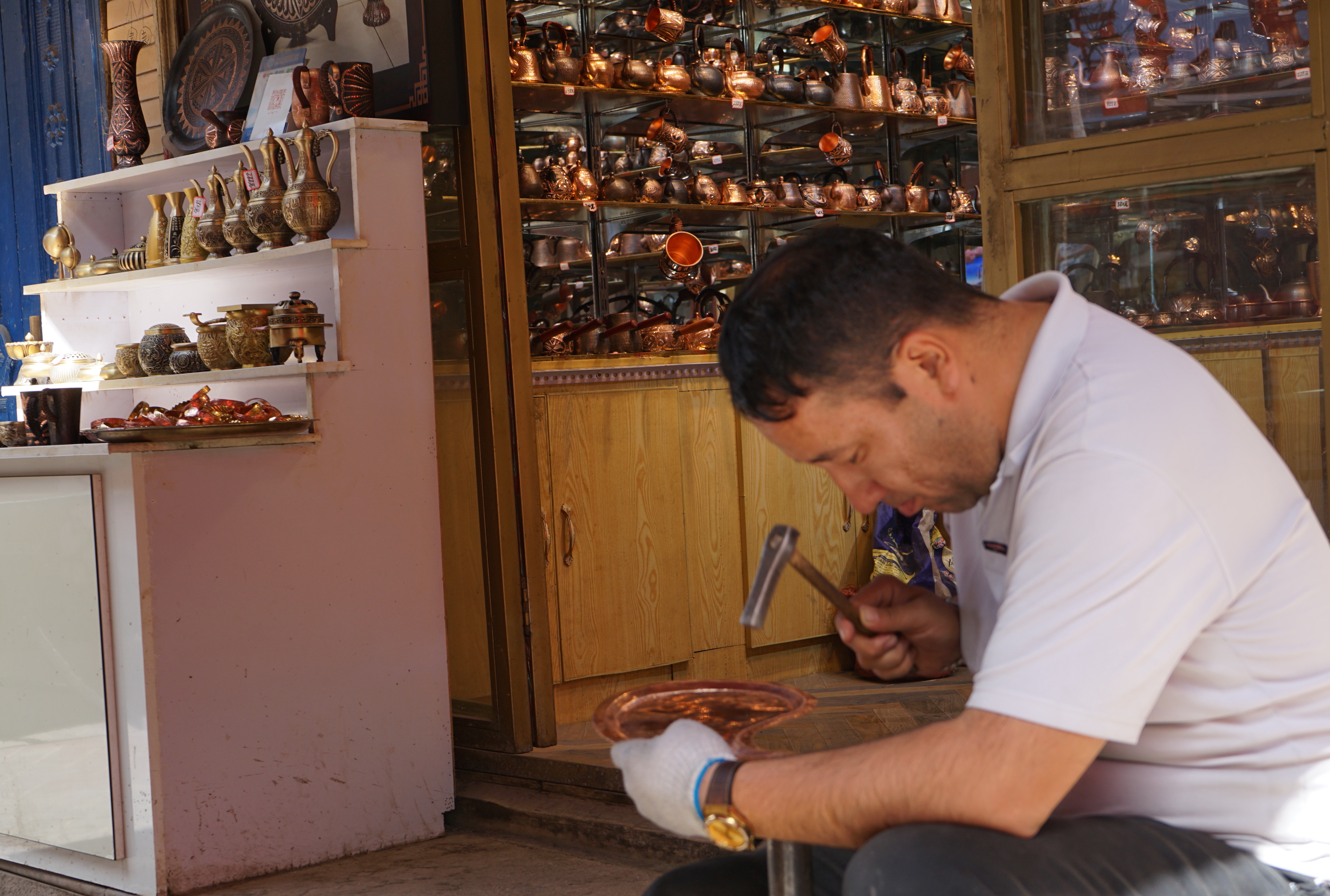 A local artisan crafts a copperwork in Kashi, China's Xinjiang. /CGTN