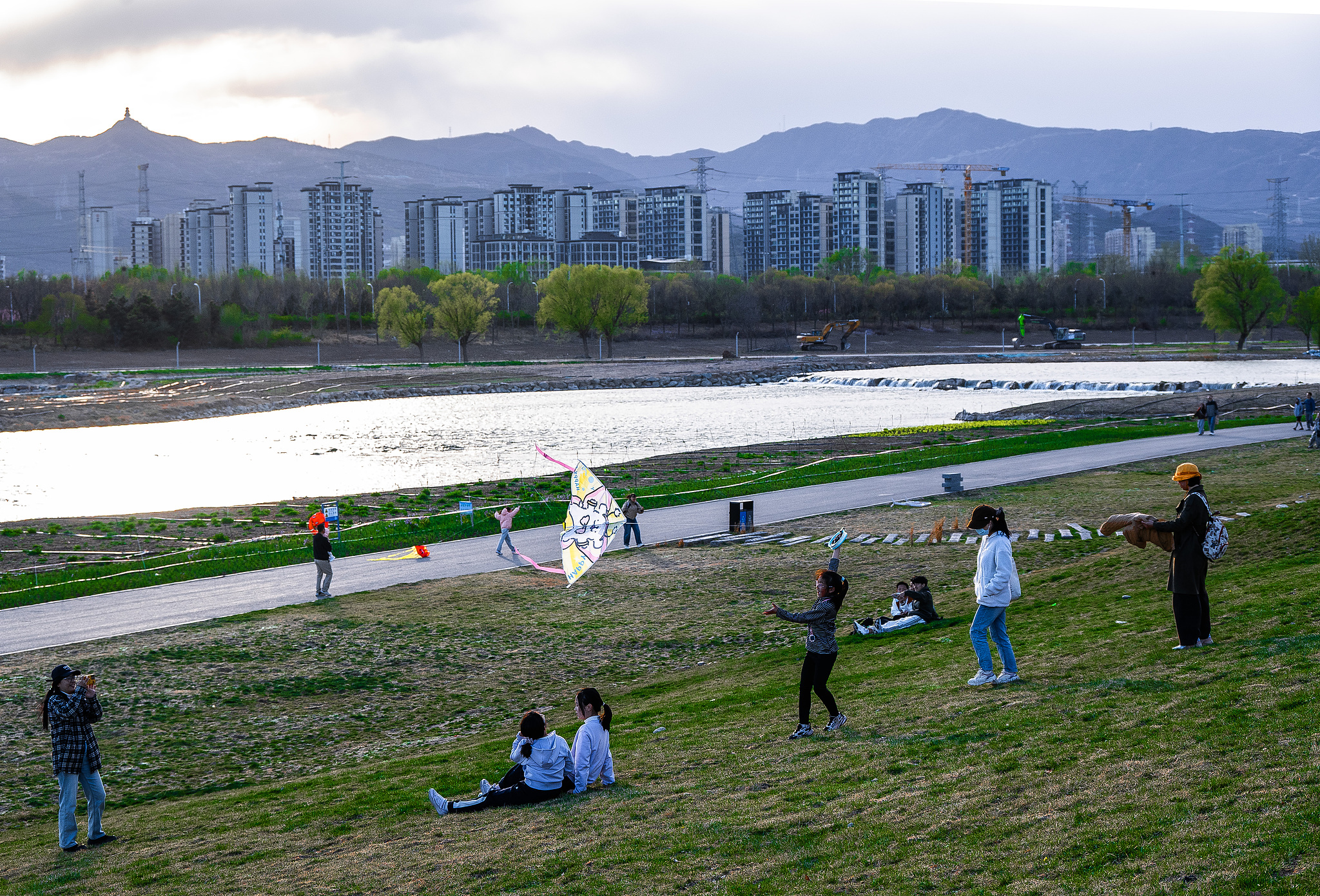 People enjoy the spring time by the Yongding River, Beijing, China, April 5, 2026. /VCG