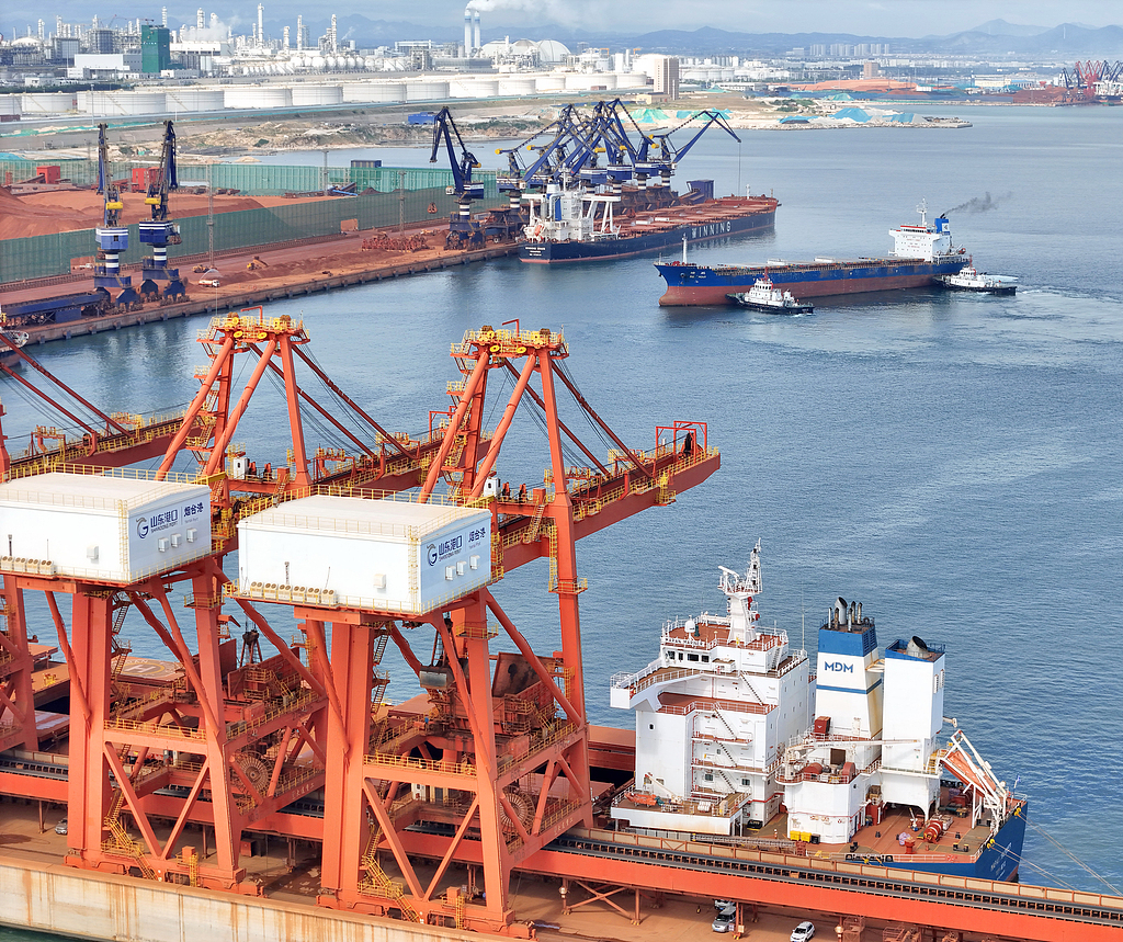 An unloader transfers bauxite ore imported from Africa from a cargo vessel at Yantai Port, China's Shangdong Province, June 13, 2025. /CFP