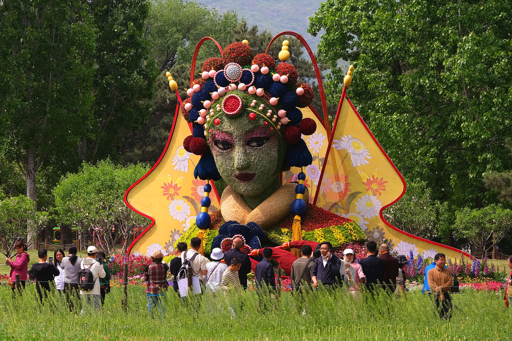 Visitors view a Peking Opera-themed floral display at the Beijing National Botanical Garden on May 2, 2026. /VCG