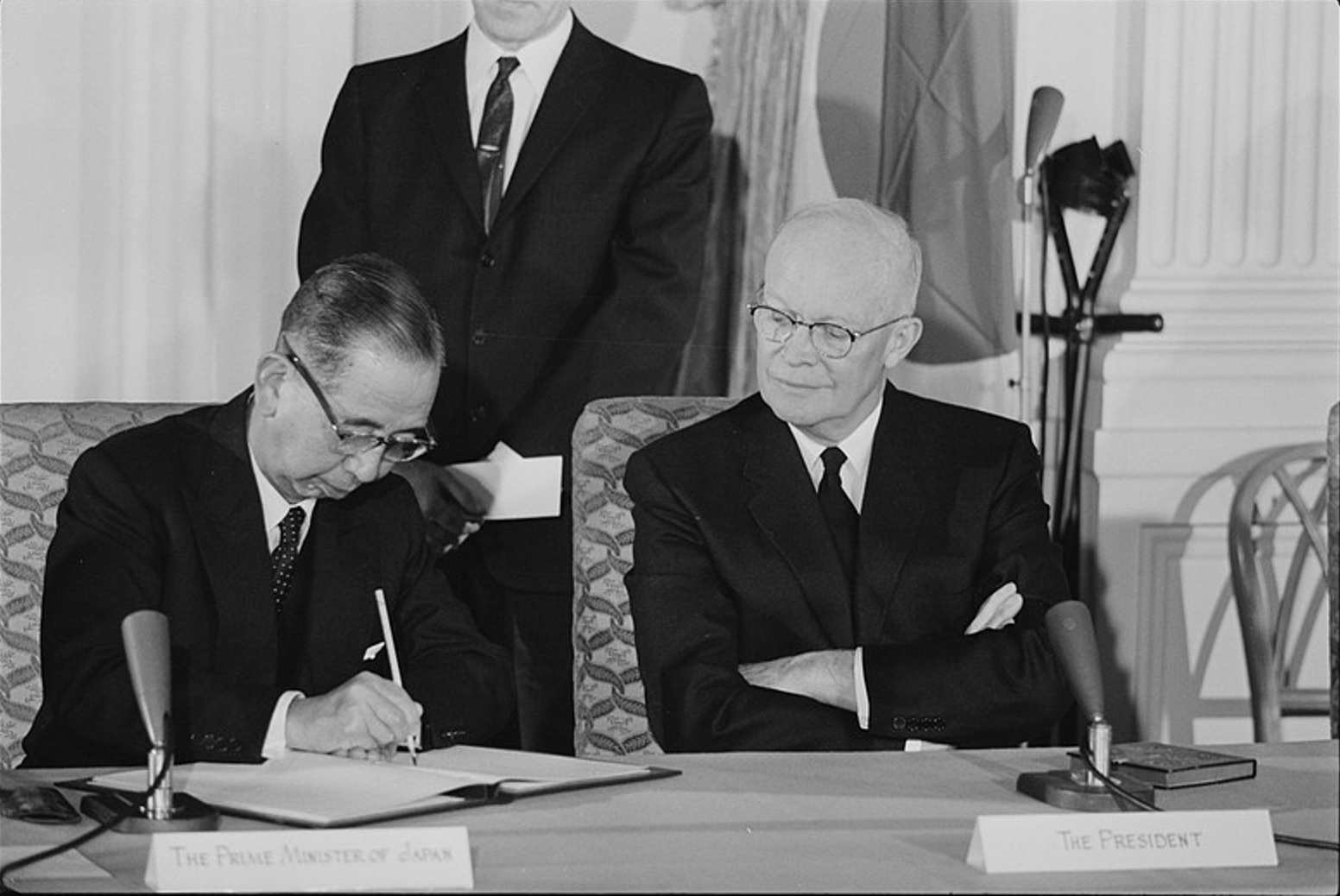 US President Dwight D. Eisenhower (R) watches as Japanese Prime Minister Nobusuke Kishi signs the Treaty of Mutual Cooperation and Security in the East Room of the White House, Washington, D.C., US, January 19, 1960. /VCG