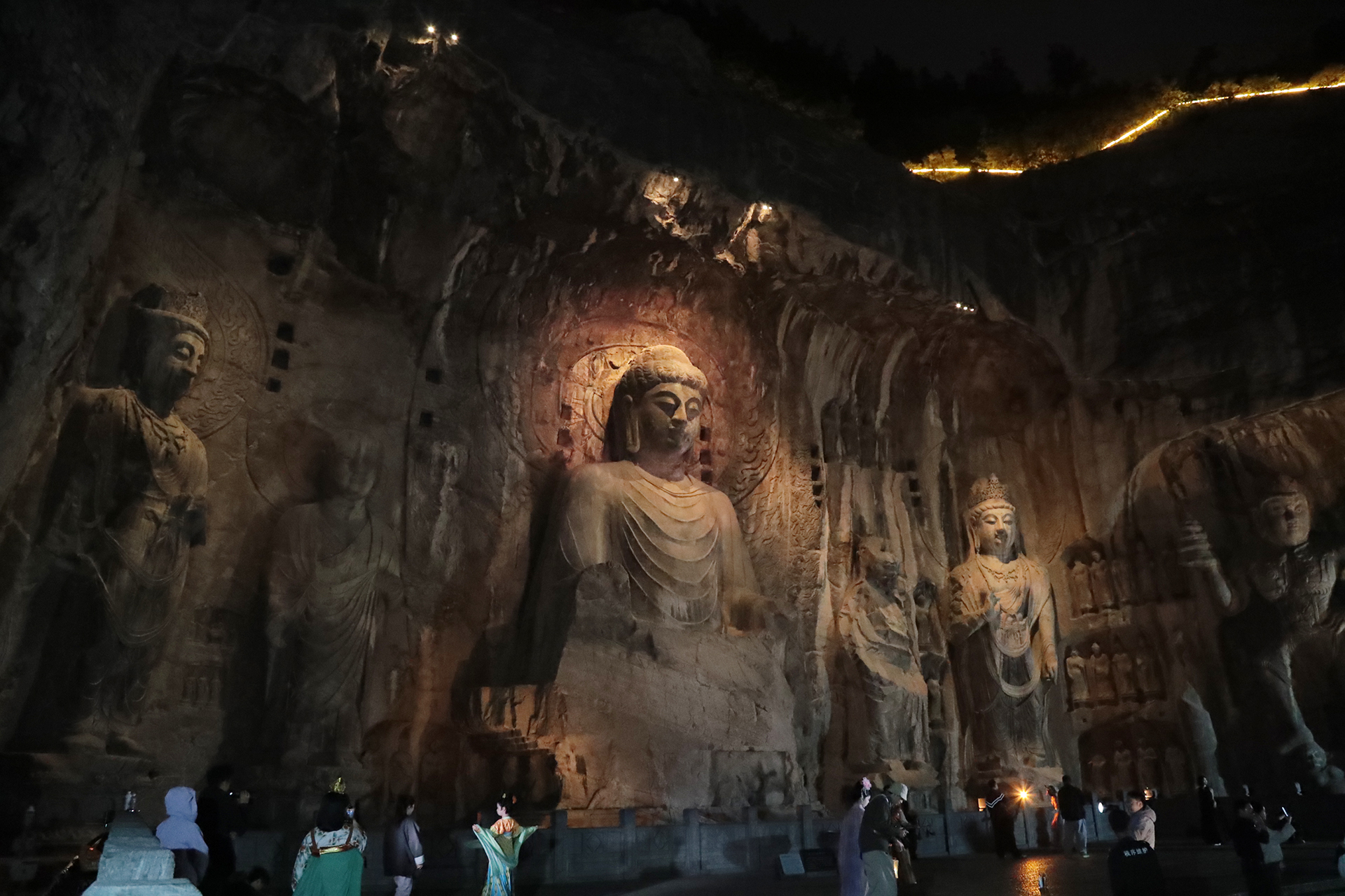 Statues at the Fengxian Temple are illuminated at night at the Longmen Grottoes in Luoyang, Henan Province. /CGTN
