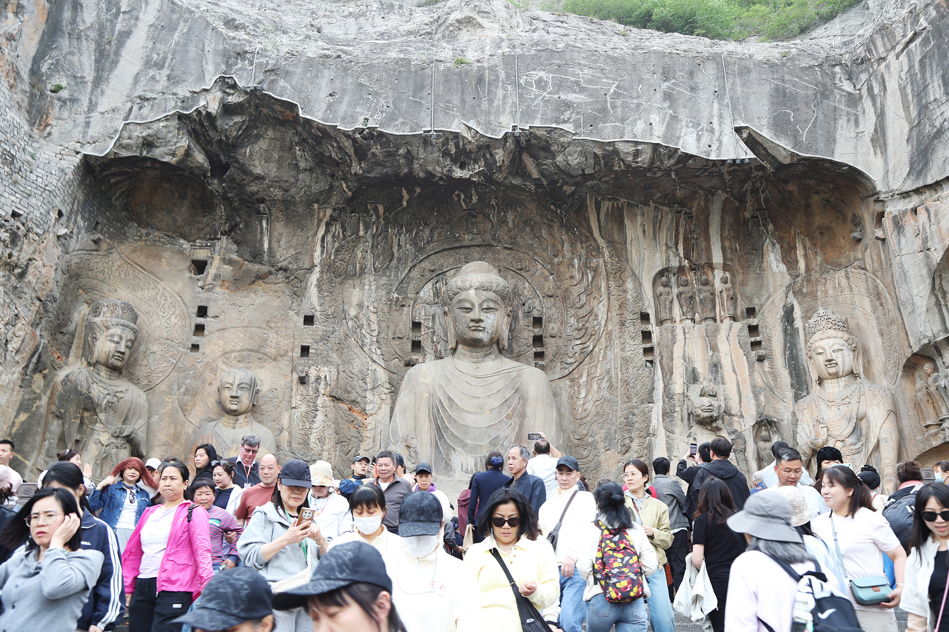 Visitors crowd the Fengxian Temple, an iconic open-air niche at the Longmen Grottoes in Luoyang, Henan Province. /CGTN