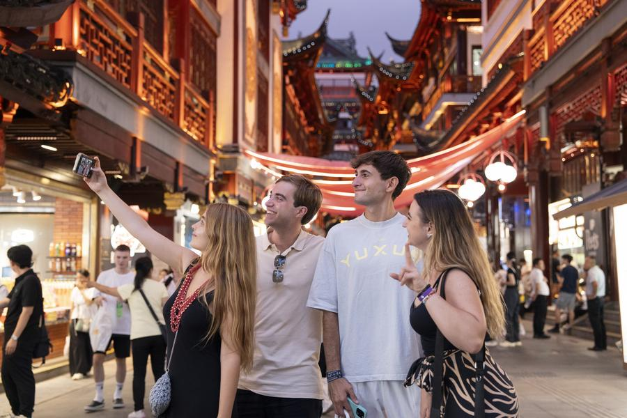 Foreign tourists take a selfie at Yuyuan Garden Mall in Shanghai, east China, July 21, 2025. /Xinhua