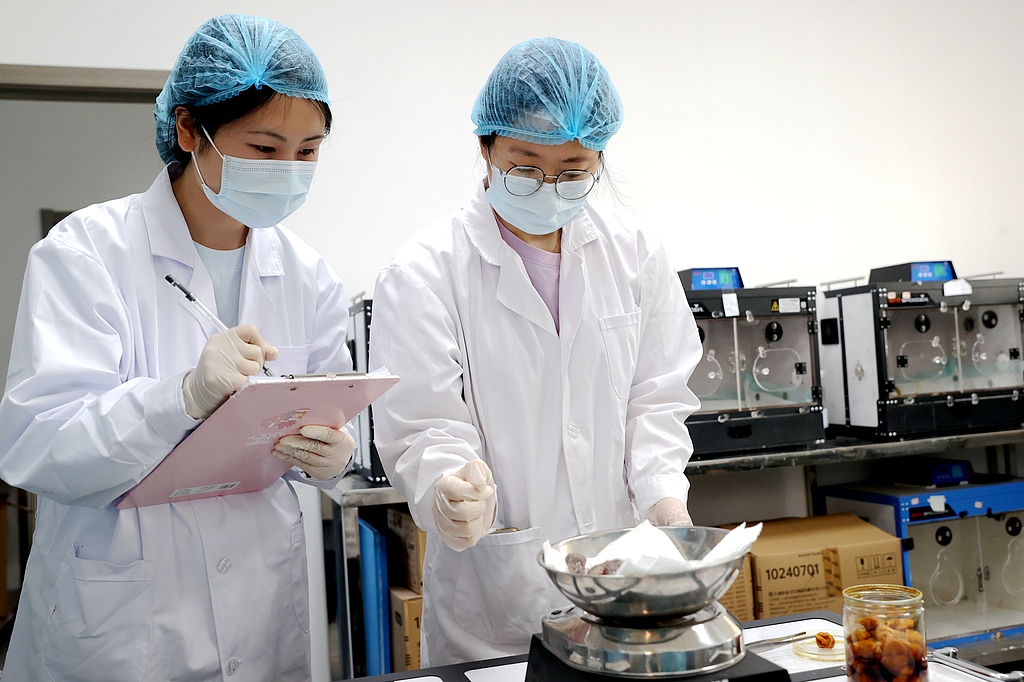 Staff at the breeding center weigh the newborn crested ibis chick in Deqing County in Huzhou, Zhejiang Province. May 6, 2026. /VCG