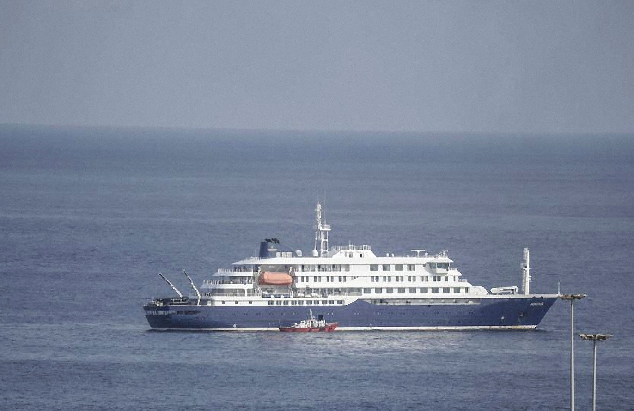 An ambulance boat position itself on the pilot door on the starboard side of the cruise ship MV Hondius, while stationary off the port of Praia, the capital of Cape Verde, on May 5, 2026. /VCG