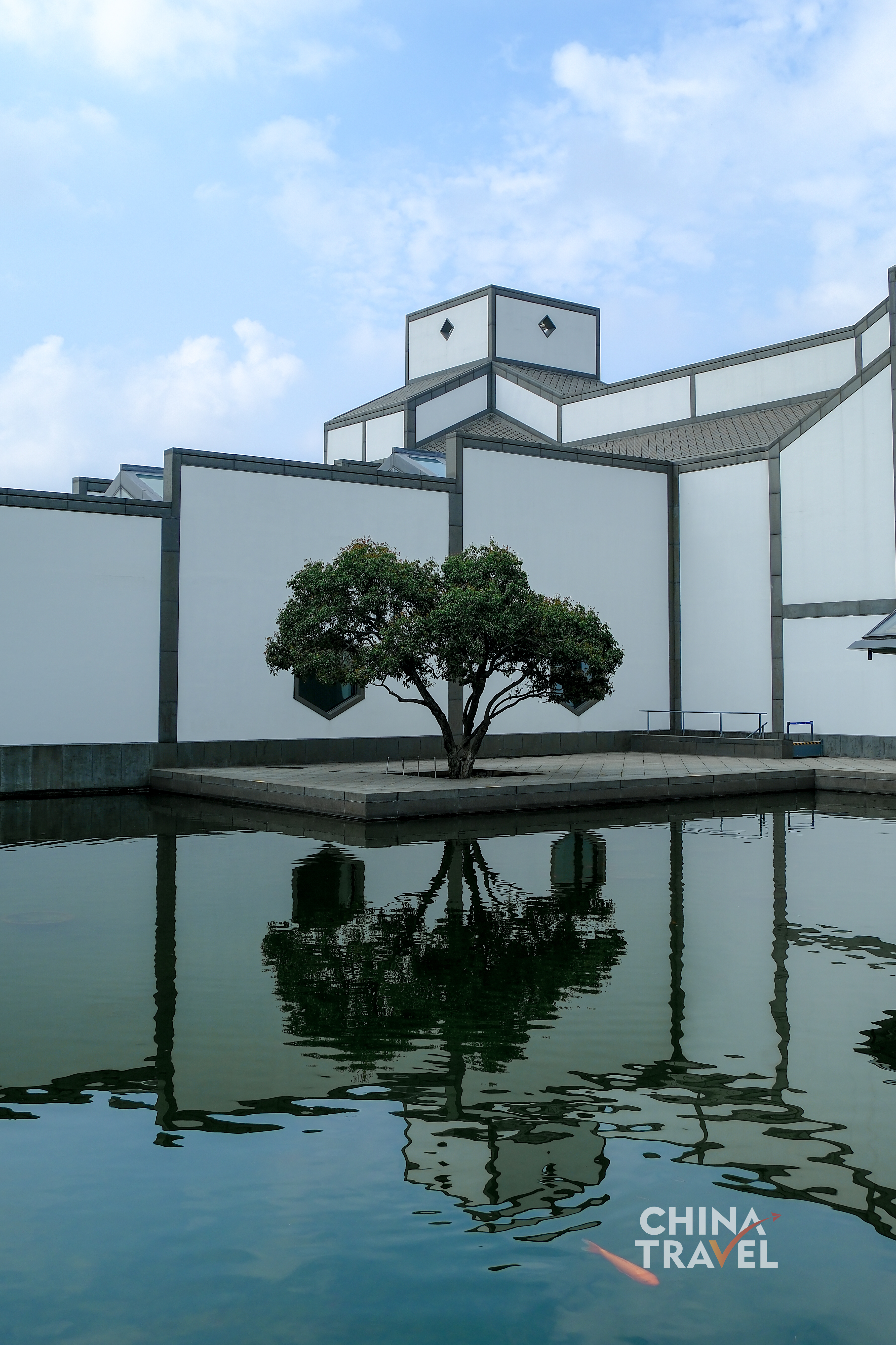 White walls and angular roofs meet still water, doubling the architecture in quiet, shifting reflections. /CGTN