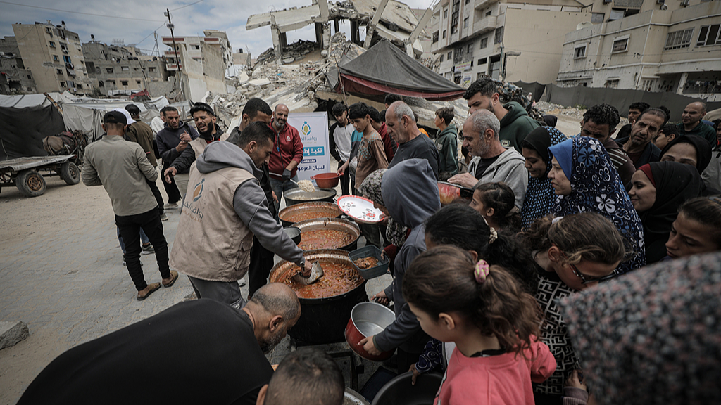 Palestinians gather to receive hot meals distributed by a charity organization in the al-Rimal neighborhood of Gaza, May 6, 2026. /VCG