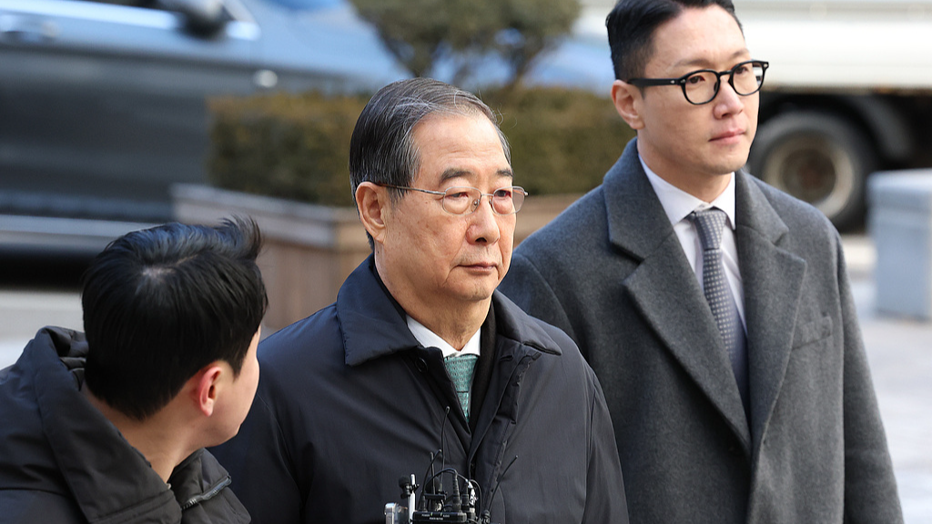 Former South Korean Prime Minister Han Duck-soo, center, arrives at the Seoul Central District Court for his first sentencing trial in the insurrection case, in Seoul, Korea, on January 21, 2026. /VCG