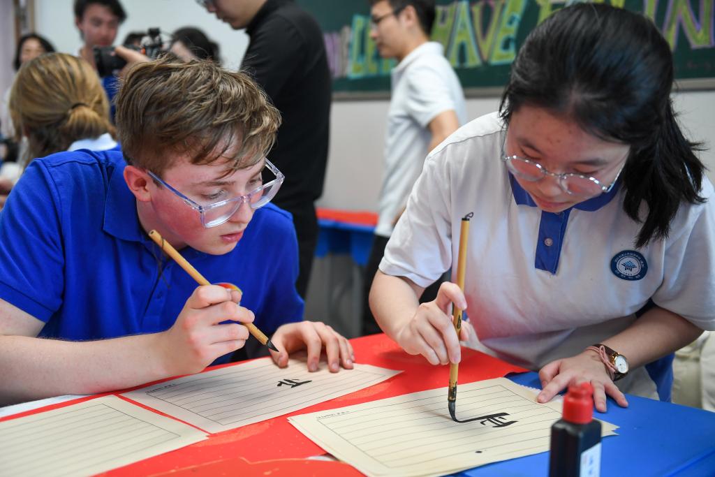 A high school student from Washington state in the United States tries Chinese calligraphy at a high school in south China's Shenzhen, March 25, 2026. /Xinhua