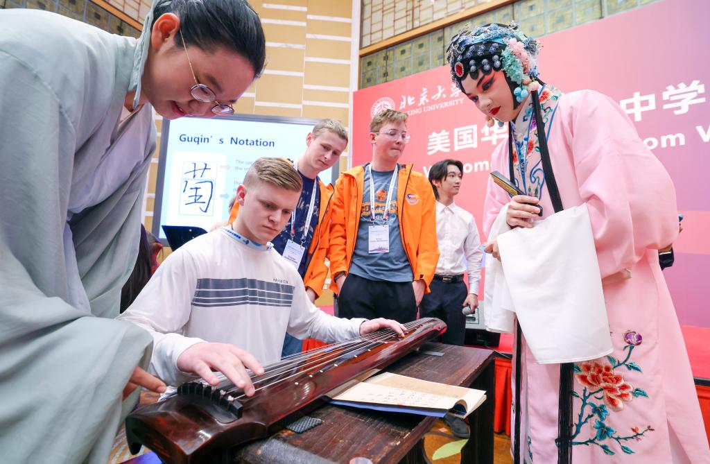 A student from Washington state in the United States is learning how to play the guqin, a traditional Chinese string instrument, at Peking University, Beijing, capital of China, March 20, 2024. /Xinhua