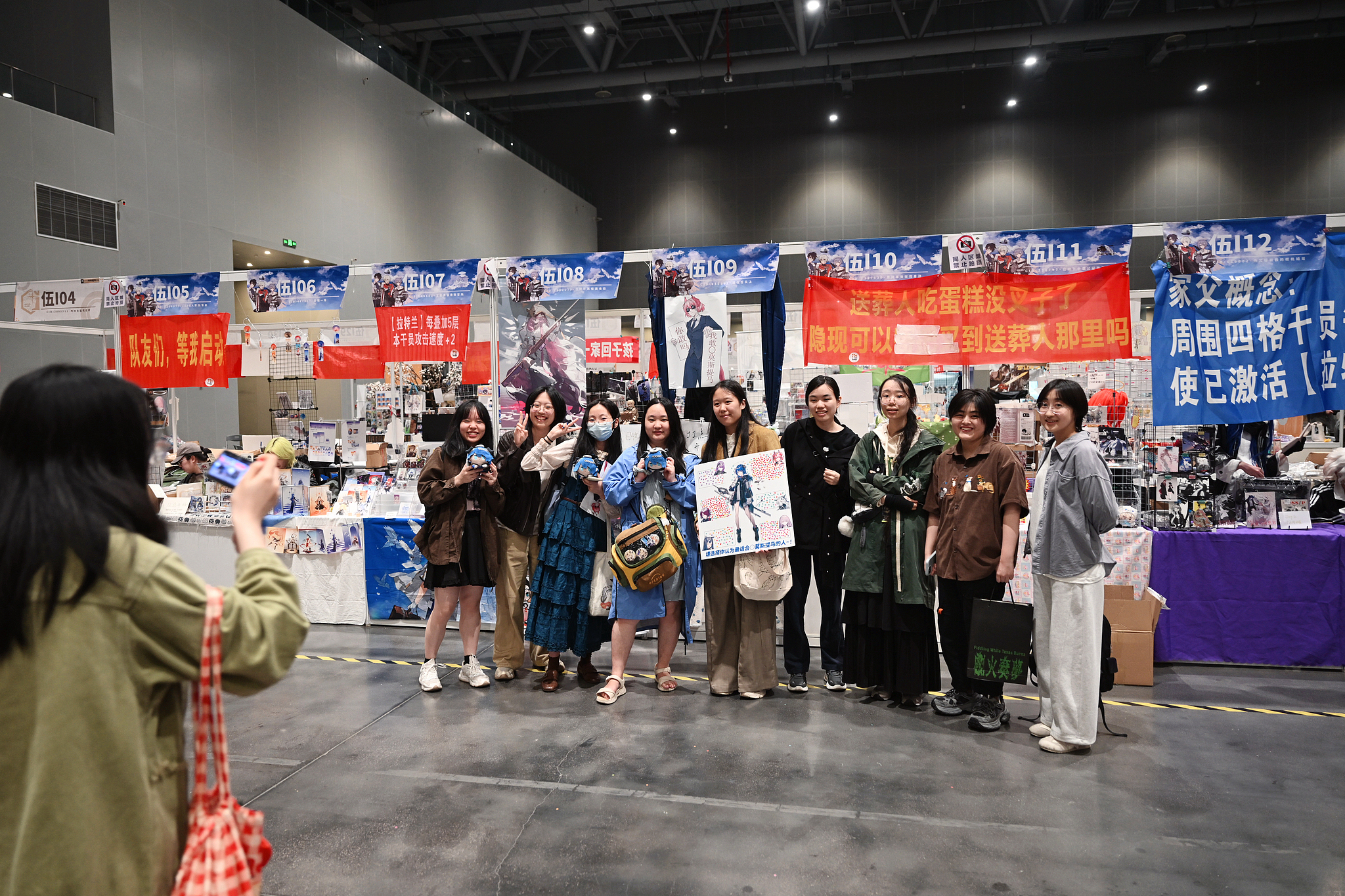 Creators pose for group photos at their booths during the CP32. /VCG