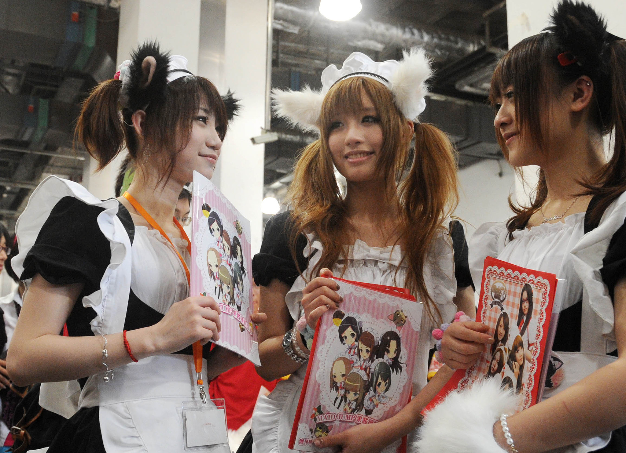 Three girls pose with character-themed boards during CP 6 in Shanghai, east China, May 24, 2010. /VCG