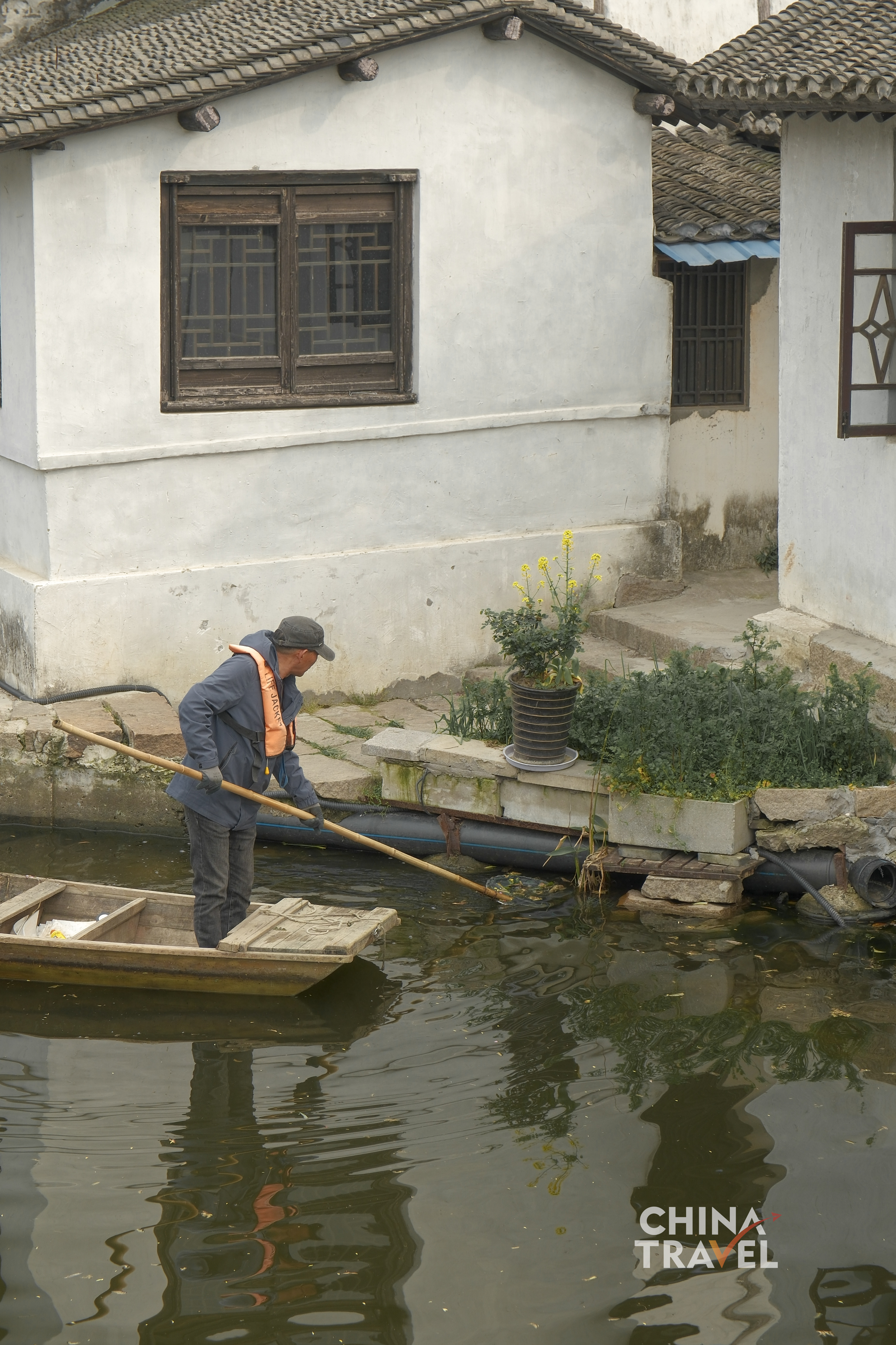 A narrow canal runs between old houses and stone bridges, carrying the quiet rhythm of a Jiangnan region waterside neighborhood. /CGTN