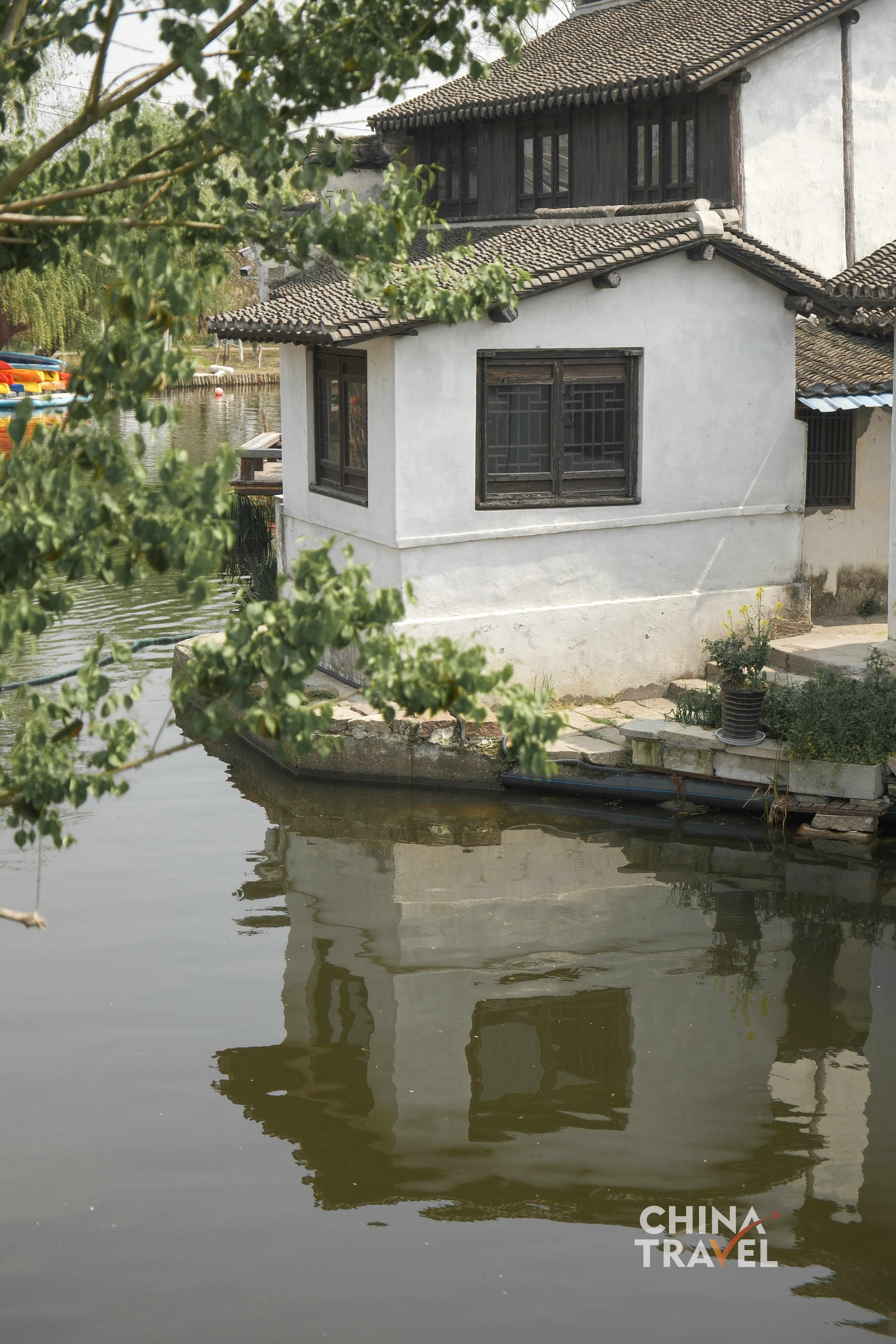 A narrow canal runs between old houses and stone bridges, carrying the quiet rhythm of a Jiangnan region waterside neighborhood. /CGTN