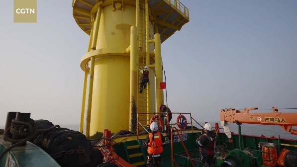 Staff carry out equipment maintenance at an offshore wind farm in Yancheng, Jiangsu Province. /CGTN