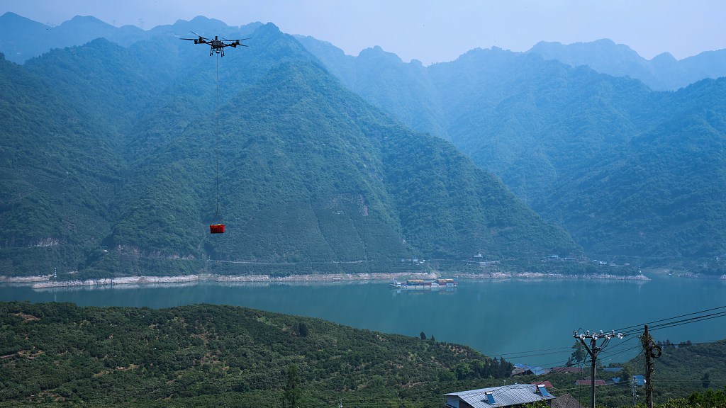 Drone operators pilot an agricultural drone to lift and transport locally grown navel oranges in Zigui, Hubei Province, China, April 26, 2026. /VCG
