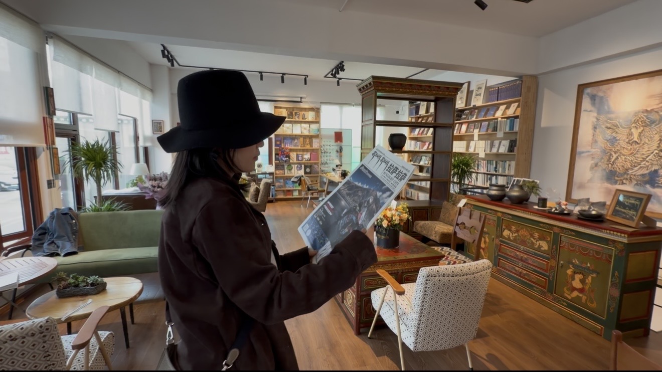 CGTN reporter Ali reading a Tibetan newspaper in a local contemporary art space in Lhasa City, southwest China's Xizang Autonomous Region. /CGTN
