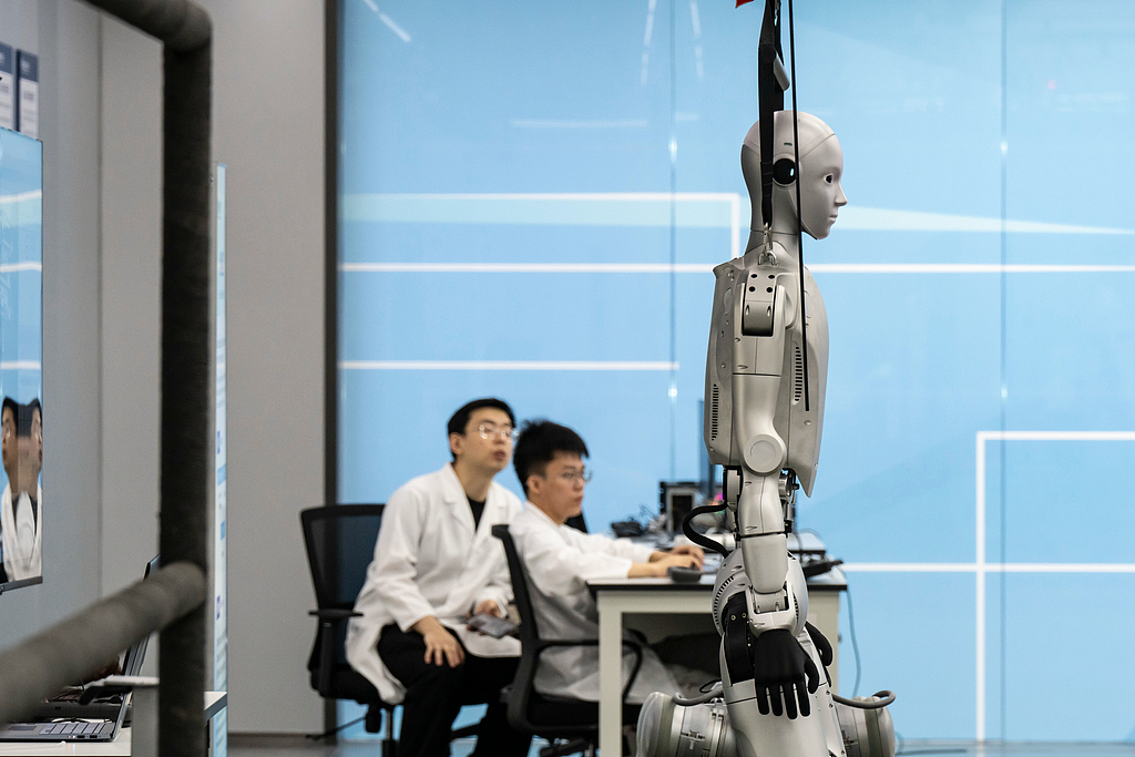 Technicians program a humanoid robot at China Southern Power Grid Co.'s Guangdong Power Grid Co. Robotics Laboratory in Guangzhou Province, China, on Thursday, April 16, 2026. /VCG