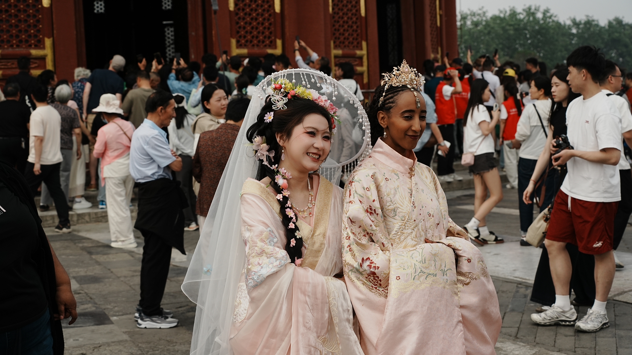 Visitors pose for photos while wearing traditional Chinese clothing at Beijing's Temple of Heaven on May 15, 2026. /VCG