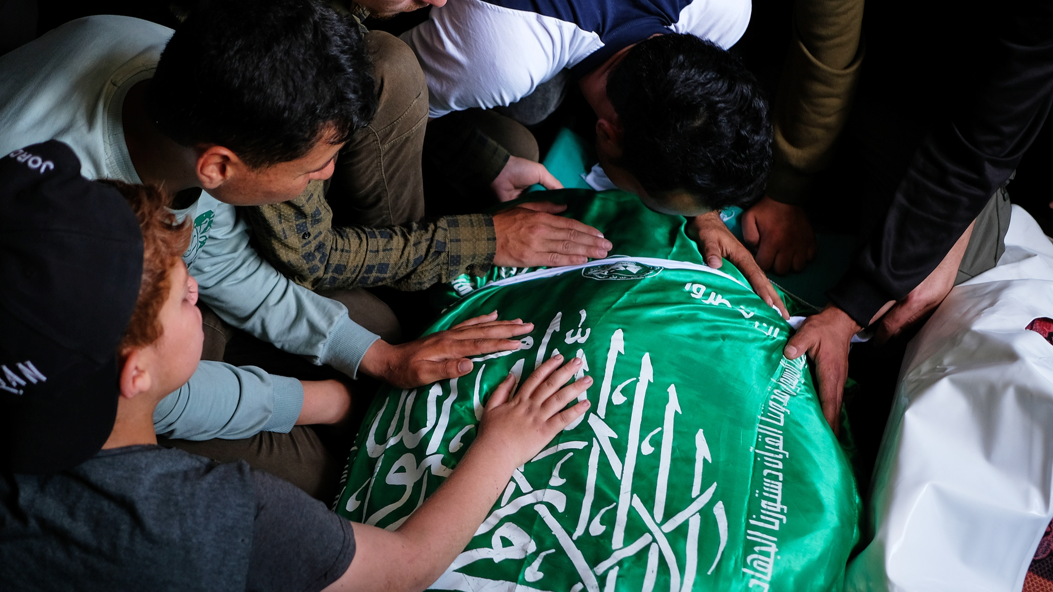 Palestinians place their hands on the body of Izz al-Din al-Haddad, commander-in-chief of Hamas' armed wing the al-Qassam Brigades, during his funeral in Gaza City, May 16, 2026. /VCG