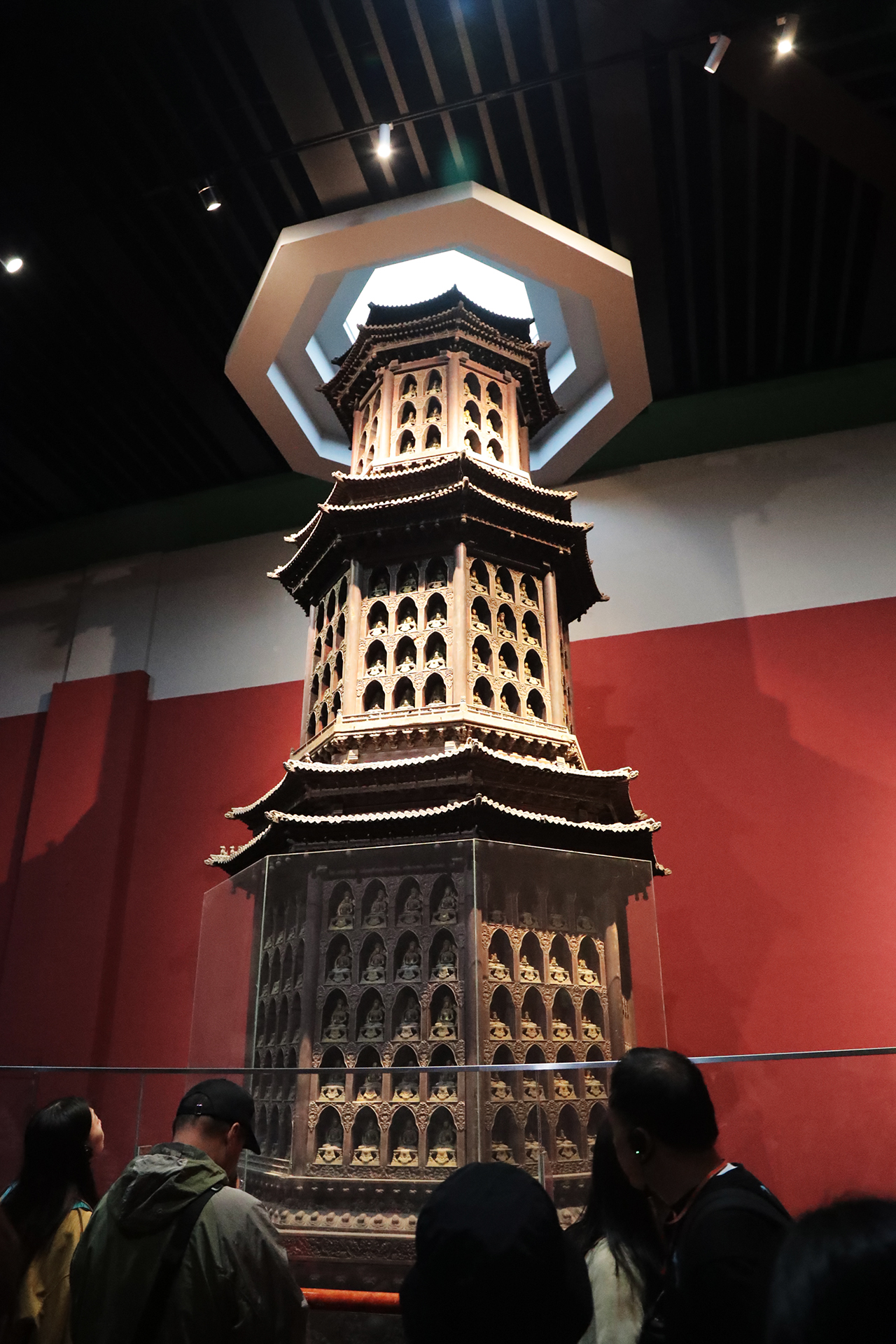 Visitors admire the Qing Dynasty golden nanmu pagoda at the Luoyang Museum in Henan Province. /CGTN