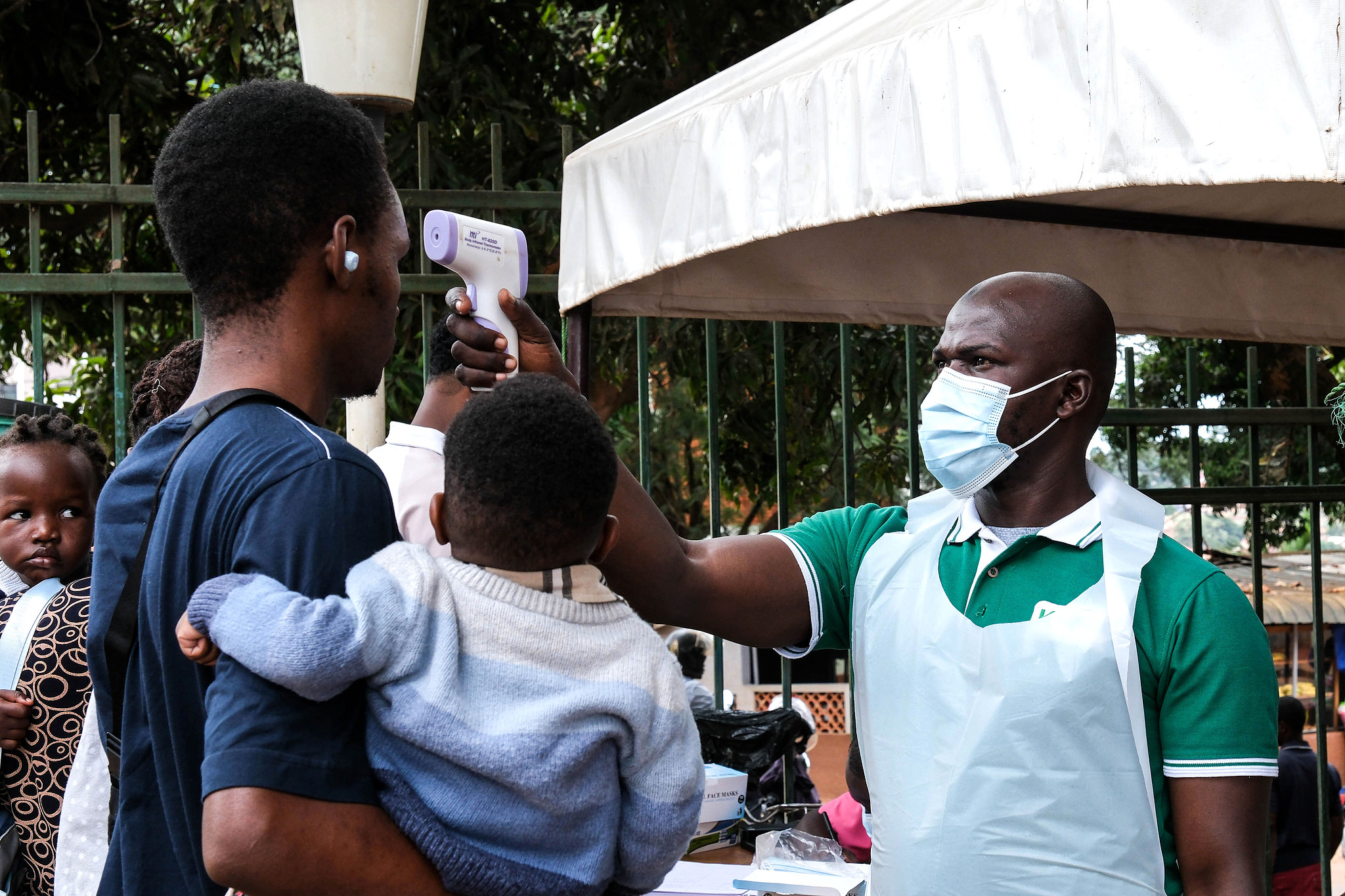 A health official uses a thermometer to screen people in front of a hospital in Kampala, Uganda, May 16, 2026. /VCG