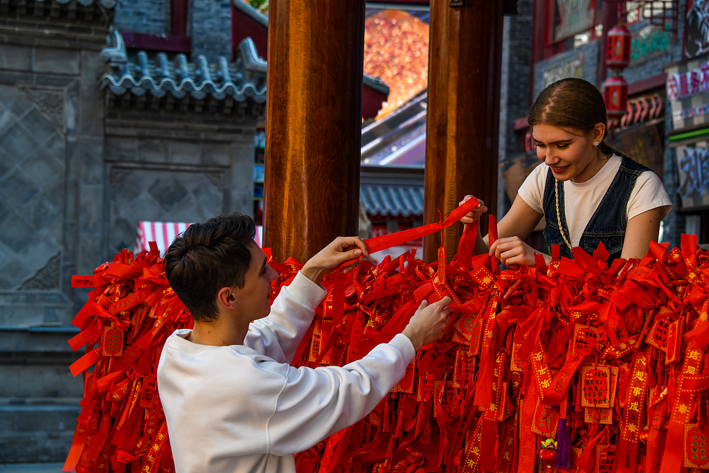 Two Russian international students take part in a traditional blessing ritual at a scenic site in Shenyang, Liaoning Province, May 11, 2025. /VCG
