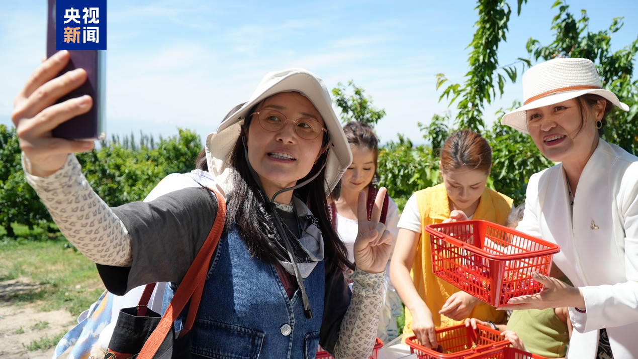 Anchors and influencers take photos with locals in northwest China's Xinjiang Uygur Autonomous Region, May 18, 2026. /CMG