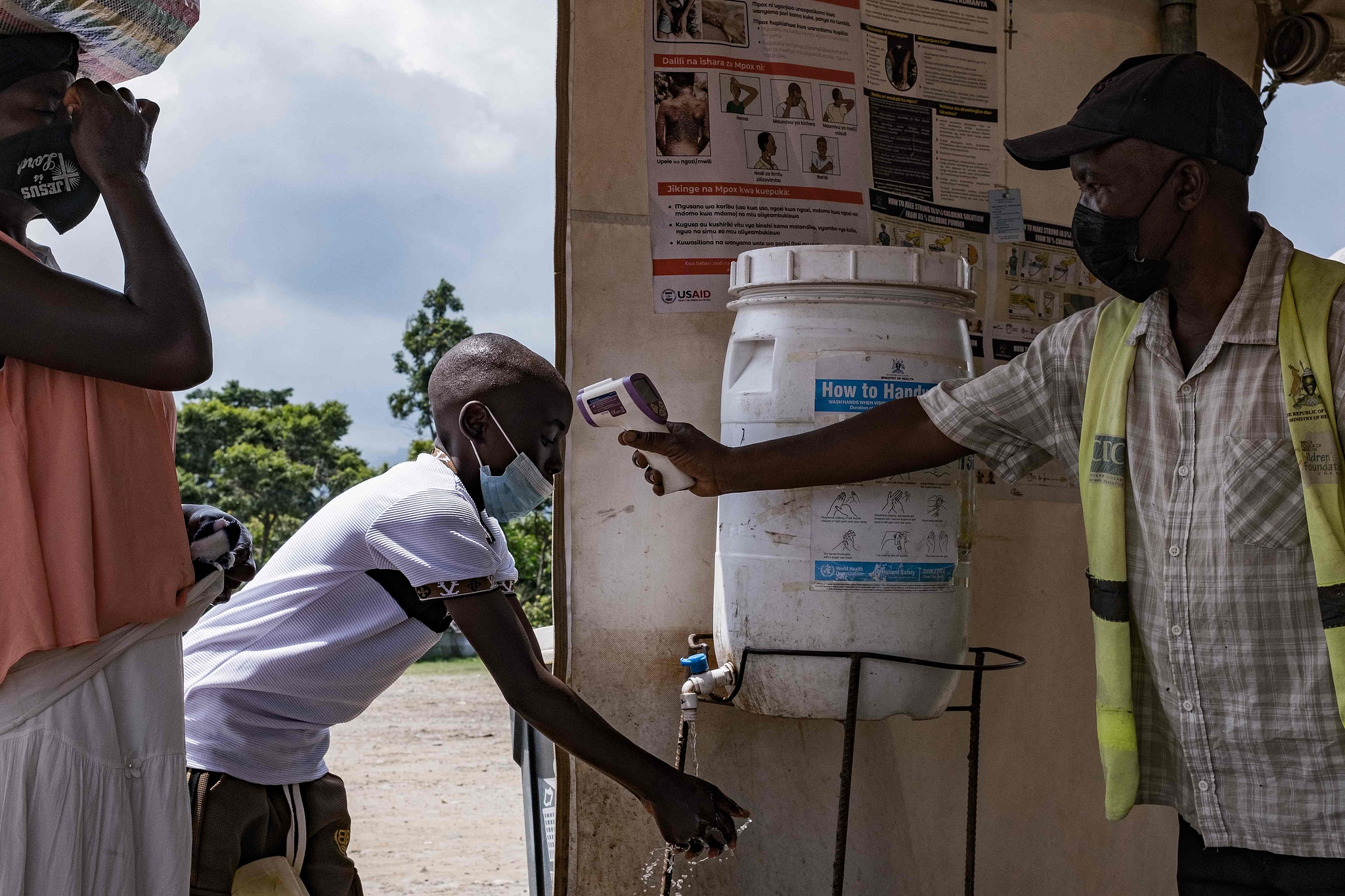 A border health officer at the Busunga crossing between Uganda and the Democratic Republic of Congo checks a traveler's temperature using a contactless infrared thermometer, May 18, 2026. /VCG