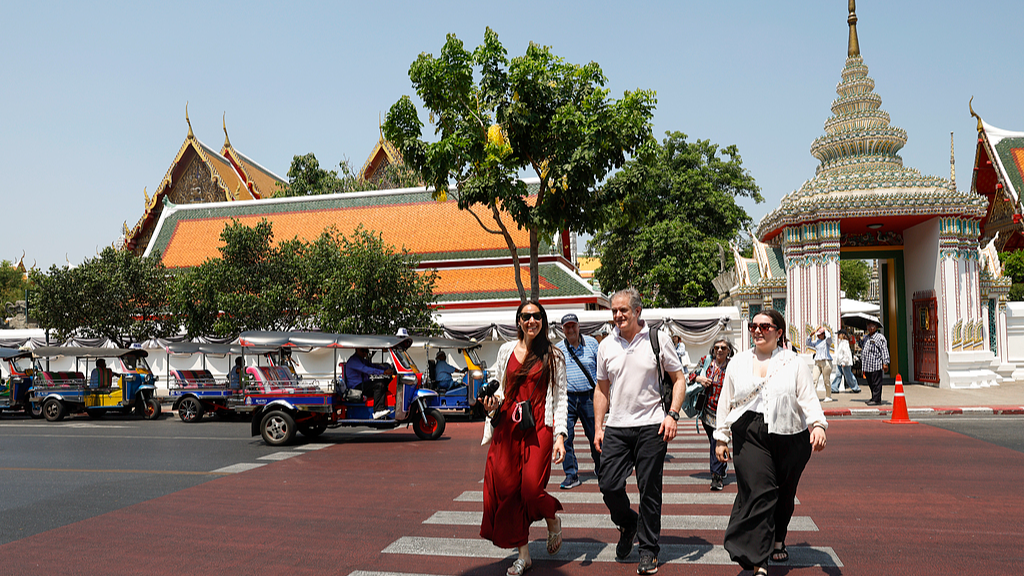 Foreign tourists cross a street after visiting the Temple of the Reclining Buddha, Bangkok, Thailand, April 7, 2026. /VCG