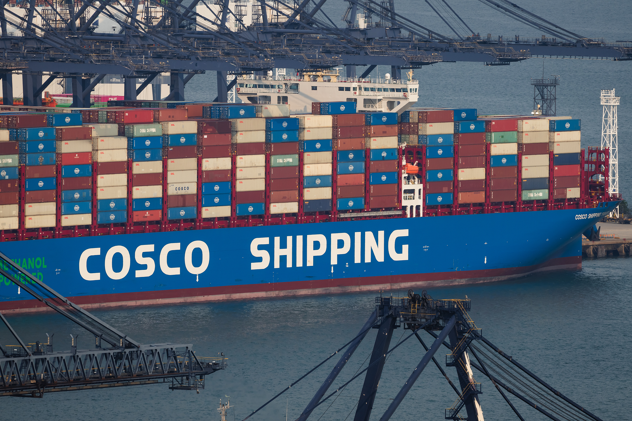 A COSCO Shipping container vessel loaded with cargo containers is seen docked beneath gantry cranes at Yantian International Container Terminals in Shenzhen, Guangdong Province, China, April 15, 2026. /VCG