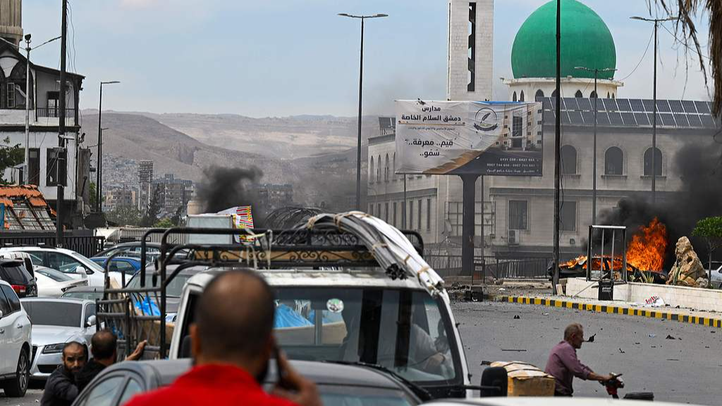 People watch as a vehicle burns following an explosion in Damascus, Syria, May 19, 2026. /VCG