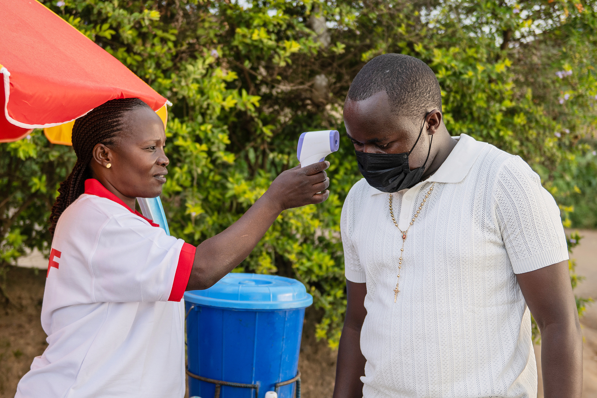 A health worker uses a thermometer to screen a man by the roadside in Bunia, Democratic Republic of the Congo, May 19, 2026. /VCG