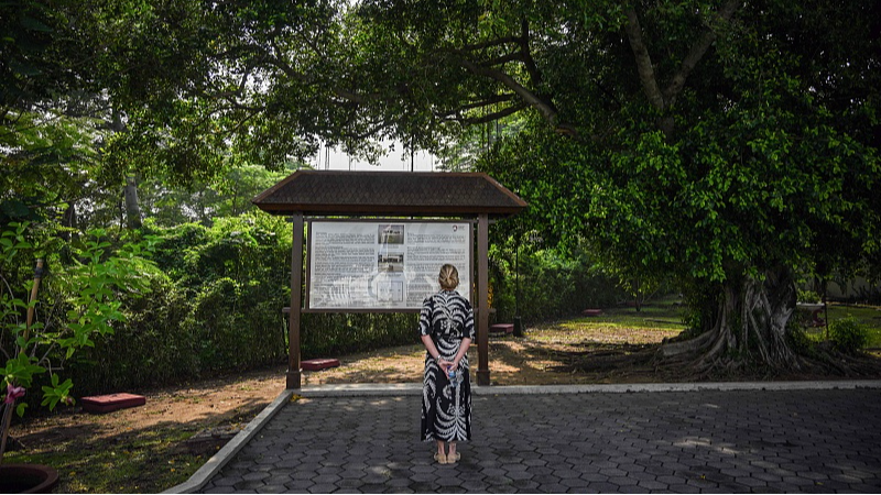 A woman looks at the historical information board during a ceremony marking the 83rd anniversary of the Battle of the Java Sea at a Dutch war cemetery in Surabaya, February 27, 2025. /CFP