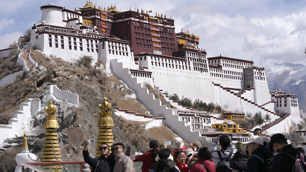 Tourists and local people take photos of the Potala Palace at the Yaowang Mountain Observation Deck, March 14, 2025. /CFP