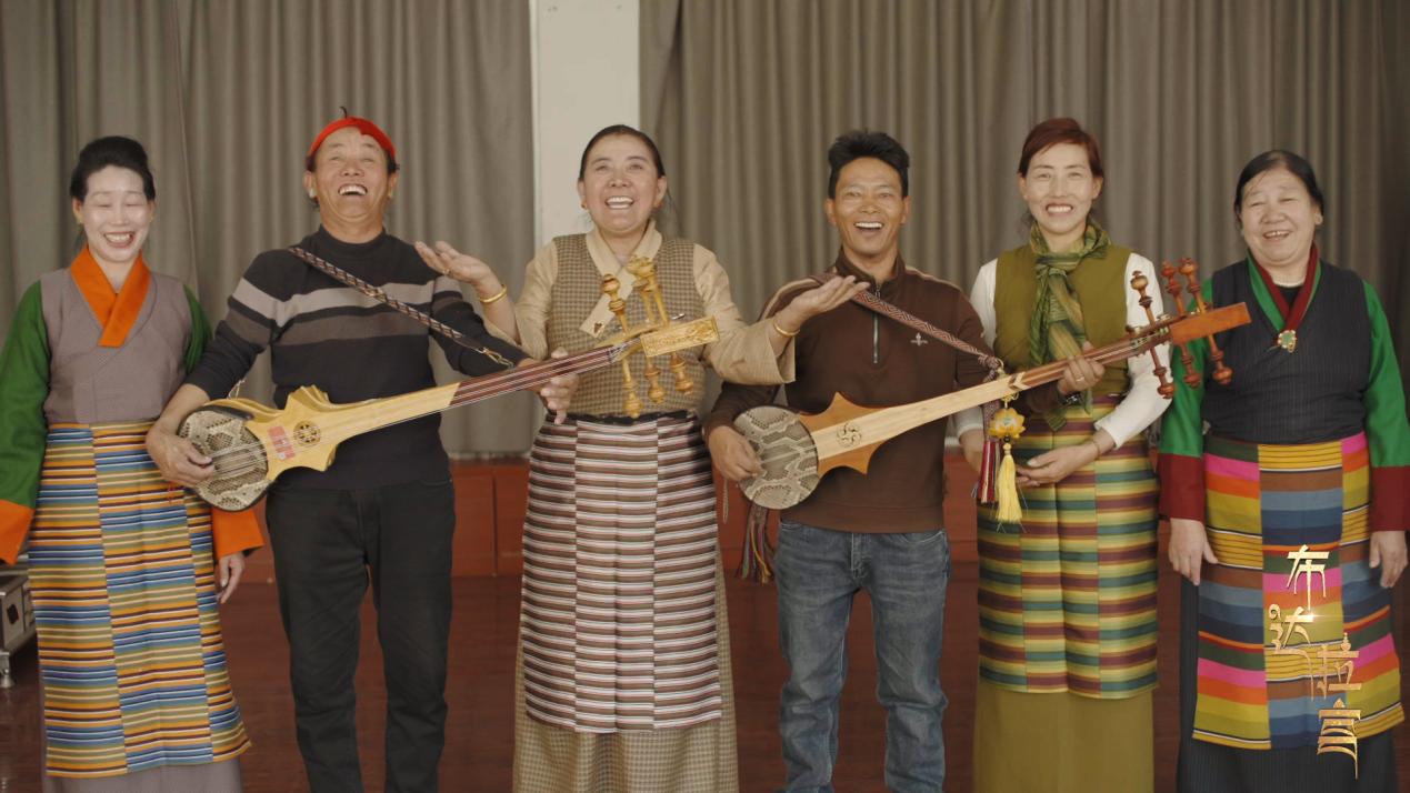 Residents of Jiangluokangsa Community pose for a picture in the activity room in Xigaze, southwest China's Xizang Autonomous Region. /CGTN