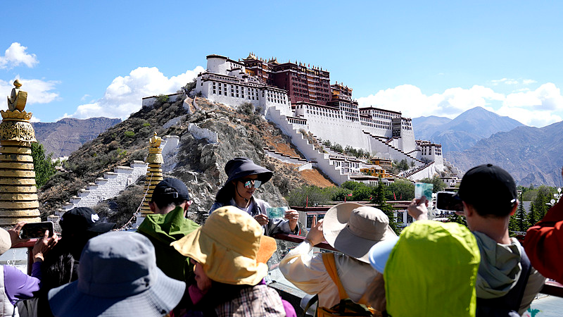 Visitors take photos with the Potala Palace in Lhasa, southwest China's Xizang Autonomous Region, May 23, 2026, the day of the 75th anniversary of the peaceful liberation of Xizang. /VCG