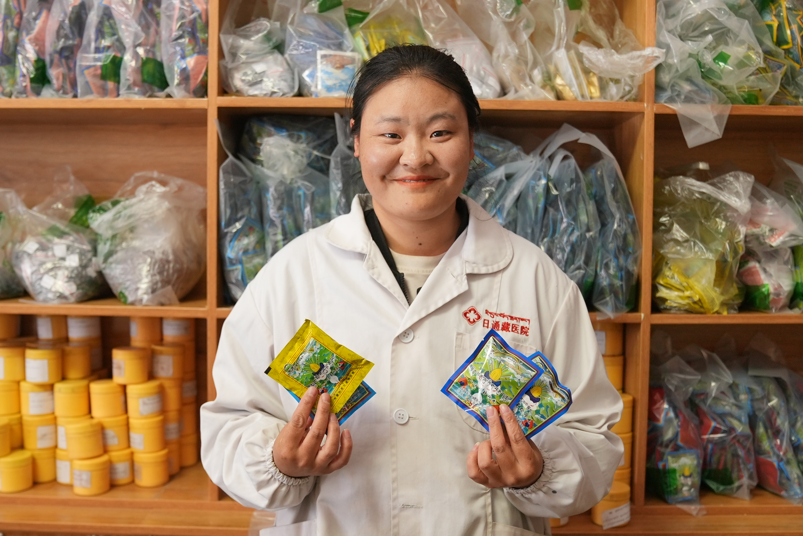 A pharmacy clerk holds up Tibetan medicine made by her hospital in Ritong Township, Xizang Autonomous Region, China, May 15, 2026. Li Jian/CGTN