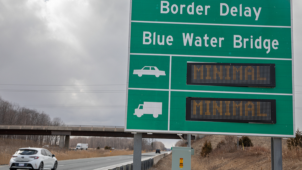 A vehicle passes signage listing border delays on the Blue Water Bridge near Sarnia, Ontario, Canada, March 12, 2026. /VCG
