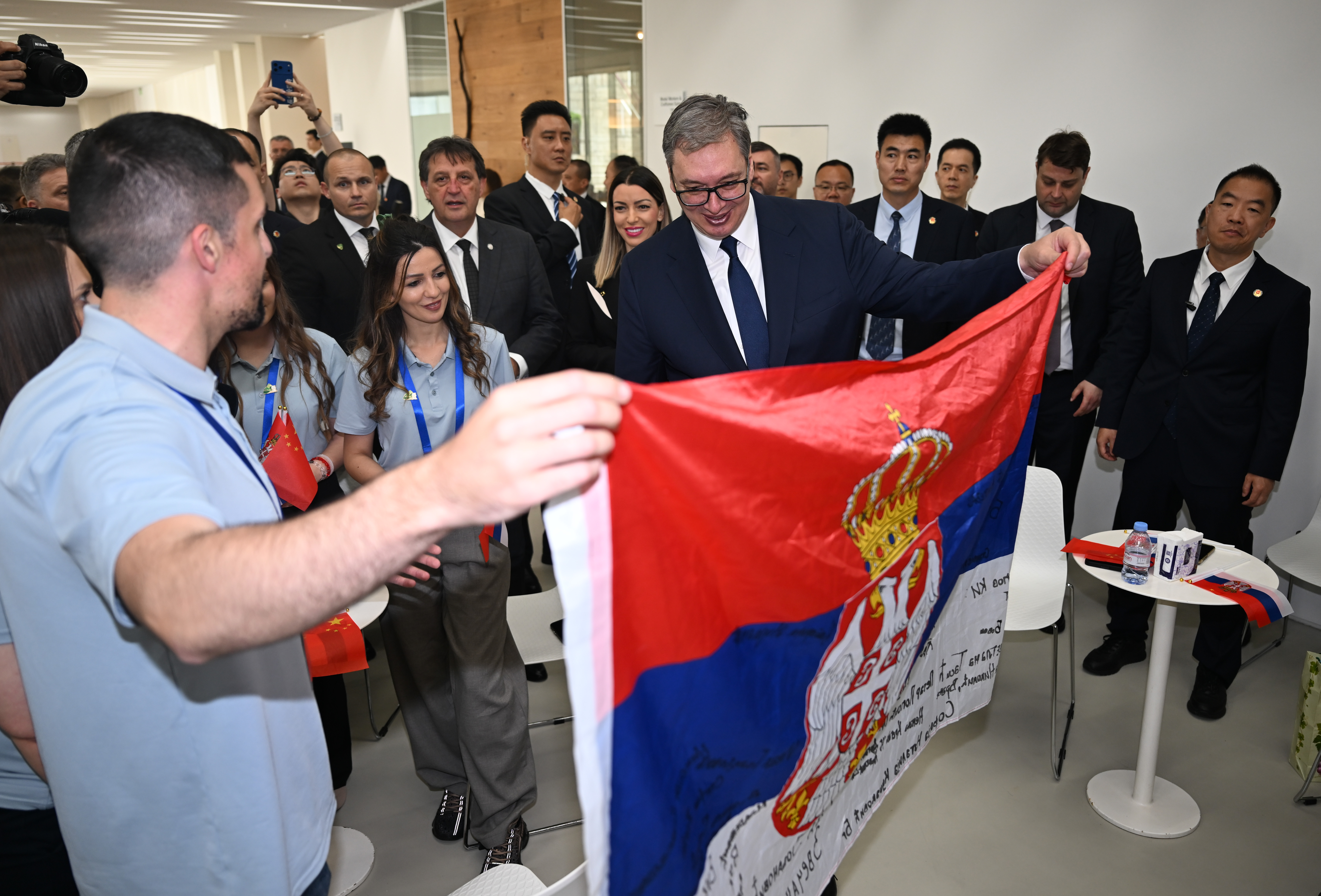 Young Serbians taking part in an exchange program in China present a Serbian flag signed with their names to Serbian President Aleksandar Vucic at the Minth Group in Jiaxing, east China's Zhejiang Province, on May 27, 2026. /IC