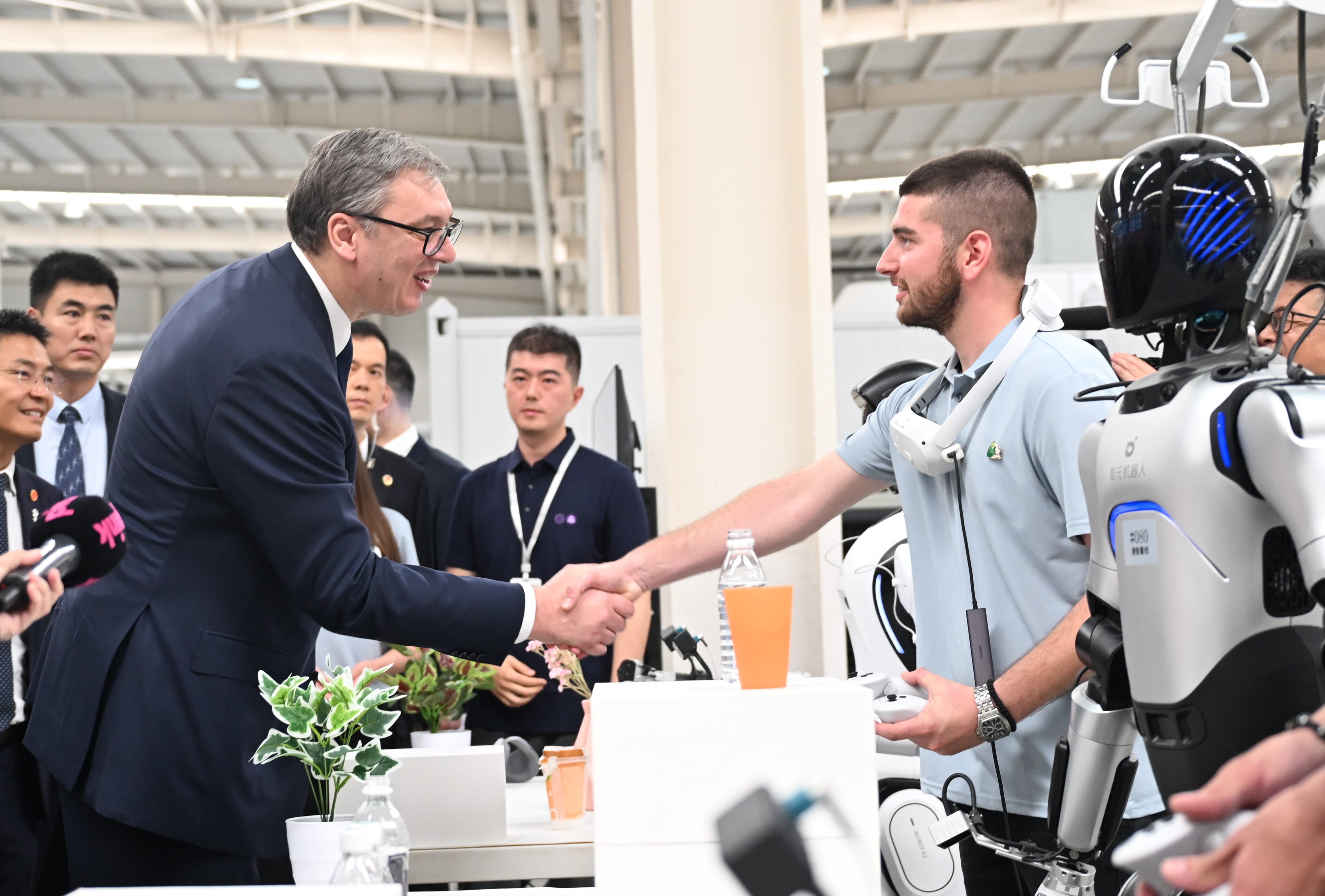 Serbian President Aleksandar Vucic talks with a young Serbian during his visit to the Minth Group in Jiaxing, east China's Zhejiang Province on May 27, 2026. /IC