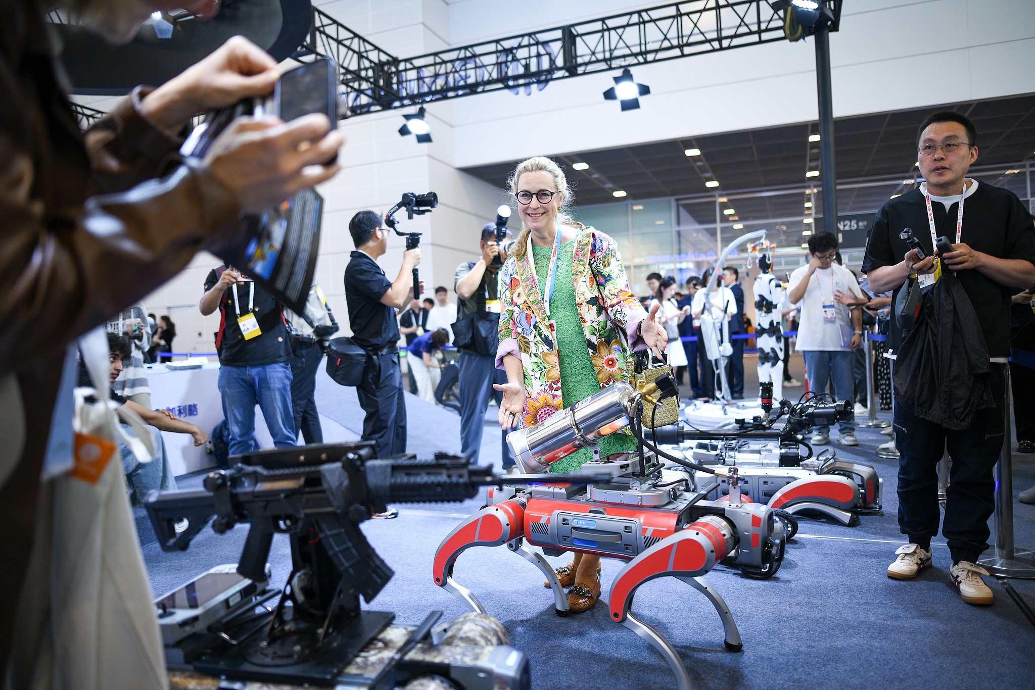 An international visitor poses for a photo with robots at the World Intelligence Expo, east China's Tianjin Municipality, May 28, 2026. /VCG
