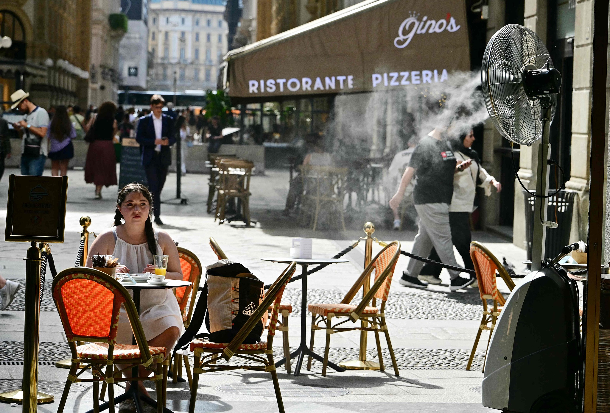A customer sits next to a misting fan to cool off in Milan, Italy, May 27, 2026. /VCG