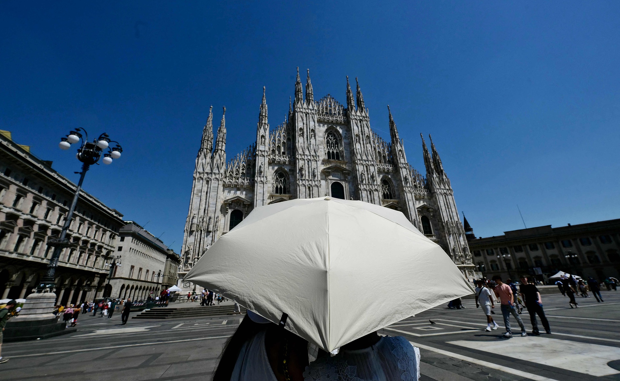 Tourists shelter from the sun in front of the Duomo Milan Cathedral, Italy, May 26, 2026. /VCG
