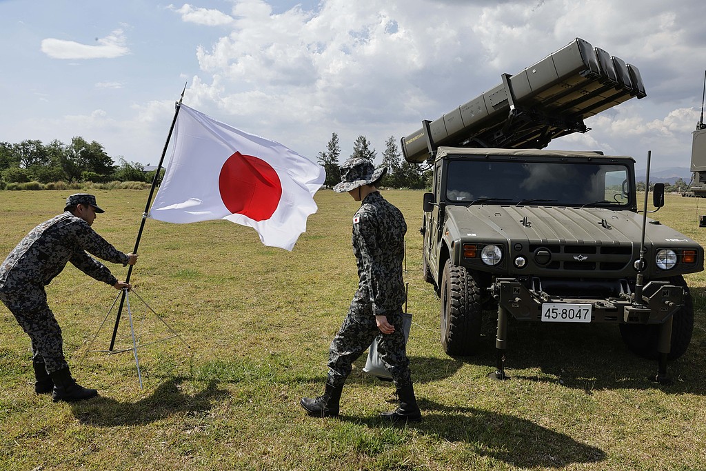 A Japan Air Self-Defense Force officer places a Japanese national flag near an observation post at a Philippine naval facility during their annual joint military drills in Zambales, the Philippines, April 28, 2026. /CFP